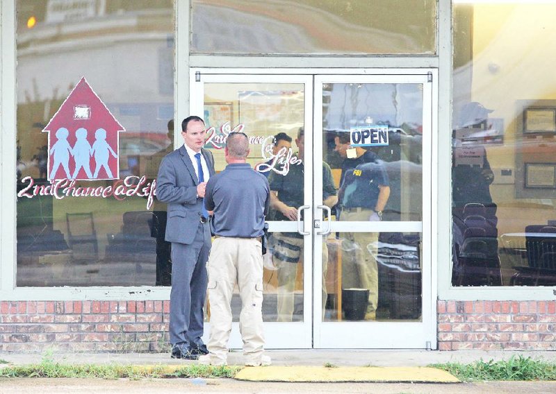 FBI agents talk outside 2nd Chance @ Life, an El Dorado organization upon which the federal investigators served a search warrant Tuesday. Another search warrant was served at the Southwestern Economic and Development Association in El Dorado.