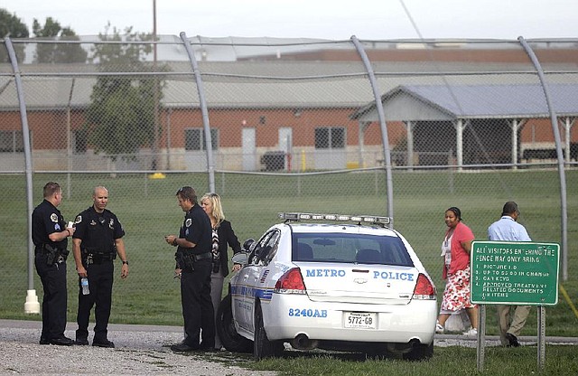 Police work in front of the Woodland Hills Youth Development Center on Tuesday in Nashville, Tenn., where 30 teens escaped late Monday by slipping under a fence.
