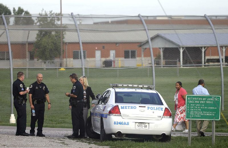 Police work in front of the Woodland Hills Youth Development Center on Tuesday in Nashville, Tenn., where 30 teens escaped late Monday by slipping under a fence.