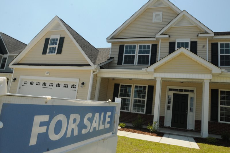 This June 19, 2014, file photo, shows a home for sale in Wilmington, N.C.  Real estate data provider CoreLogic reports on U.S. home prices in July. In June, prices rose by the smallest year-over-year amount in 20 months, slowed by modest sales and more properties coming on the market. The slowing increases should make homes more affordable after prices had risen sharply last year. At the same time, Americans' pay hasn't risen nearly as fast.