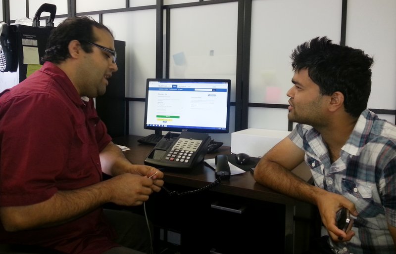 This photo taken Friday, Aug. 29, 2014 and made available by Amy Jones, shows Shekhar Bastola, a SEAMAAC Bhutanese outreach worker, left, assisting Bhagawat Bastola with his immigration documents in Philadelphia. Bastola is helping Bastola with the status of his immigration documents submitted to purchase health insurance under the Affordable Care Act. 