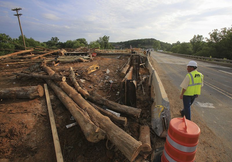 Arkansas Democrat-Gazette/STATON BREIDENTHAL, file — 6/2/14 — A construction worker overlooks the scene of a double-fatality accident on the evening of June 2 near the intersection of Highway 65 and Highway 16 in Clinton. Officials said a log truck lost control and slid onto a bridge under construction, killing two workers and injuring 19 others.