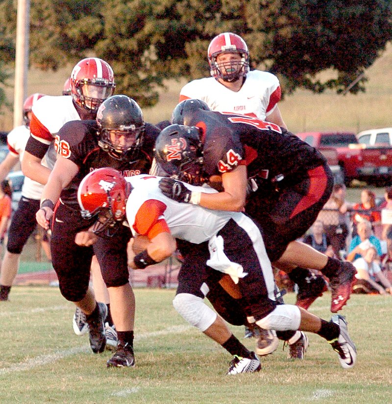 RICK PECK MCDONALD COUNTY PRESS McDonald County&#8217;s Jarrett Sanny (44) rides Aurora quarterback Payton Evans to the ground during Houn Dawgs&#8217; 27-6 win Friday night at MCHS.