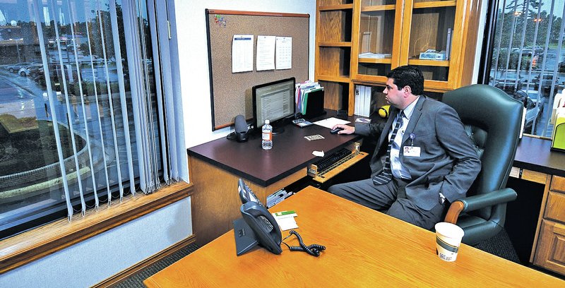 STAFF PHOTO J.T. Wampler Sharif Omar, new CEO of Northwest Health System, works Tuesday in his Springdale office.