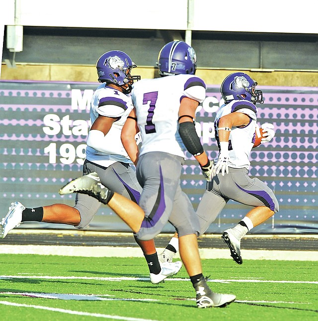 FILE PHOTO ANDY SHUPE Miles Taliaferro, right, Fayetteville safety, carries the ball into the end zone Aug. 25 after making an interception against Greenwood at Harmon Stadium in Fayetteville.