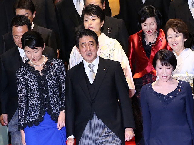 Japanese Prime Minister Shinzo Abe arrives for a group photo in Tokyo with his new Cabinet, including five female ministers (from left) Yuko Obuchi, Sanae Takaichi, Haruko Arimura, Eriko Yamatani and Midori Matsushima.