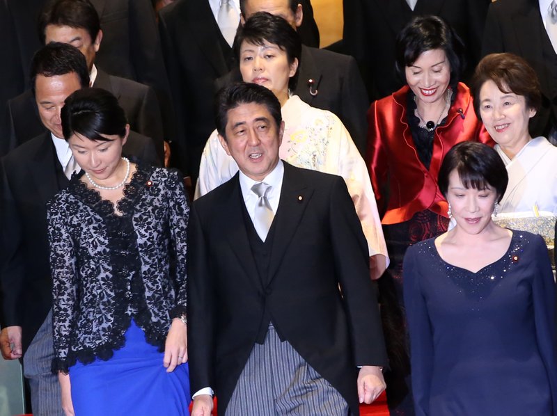 Japanese Prime Minister Shinzo Abe arrives for a group photo in Tokyo with his new Cabinet, including five female ministers (from left) Yuko Obuchi, Sanae Takaichi, Haruko Arimura, Eriko Yamatani and Midori Matsushima.