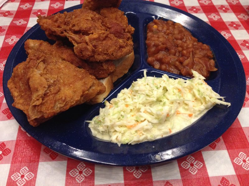 A half chicken is served with coleslaw and beans at Gus’s World Famous Fried Chicken in west Little Rock.