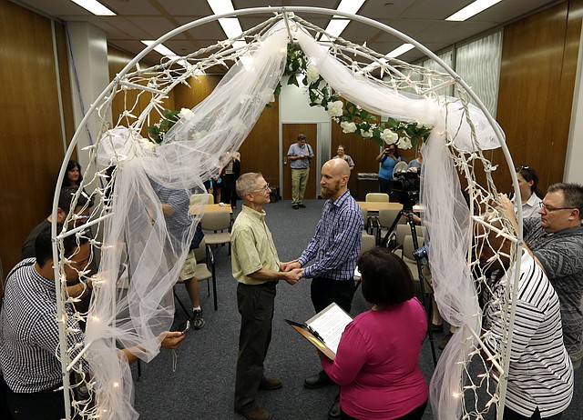  In this June 25, 2014 file photo Bart Peterson, left, and Pete McNamara are married by Marion County Clerk Beth White in Indianapolis after a federal judge struck down a state ban on same-sex marriage. Same-sex marriage bans in both Indiana and Wisconsin were overturned in June and then appealed by the attorneys generals of both states. A U.S. appeals court in Chicago ruled Thursday, Sept. 4, 2014 that gay marriage bans in Wisconsin and Indiana violate the U.S. Constitution  thereby bumping the number of states where gay marriage will be legal from 19 to 21. 