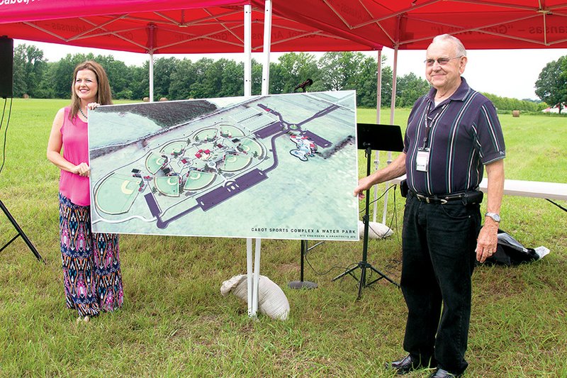 At a ribbon cutting earlier this summer for the new Cabot Sports and Aquatic Complex, Maggie Cope, chairwoman of the Cabot Parks and Recreation Commission, and Cabot Mayor Bill Cypert hold up an artist’s rendering of the new complex.