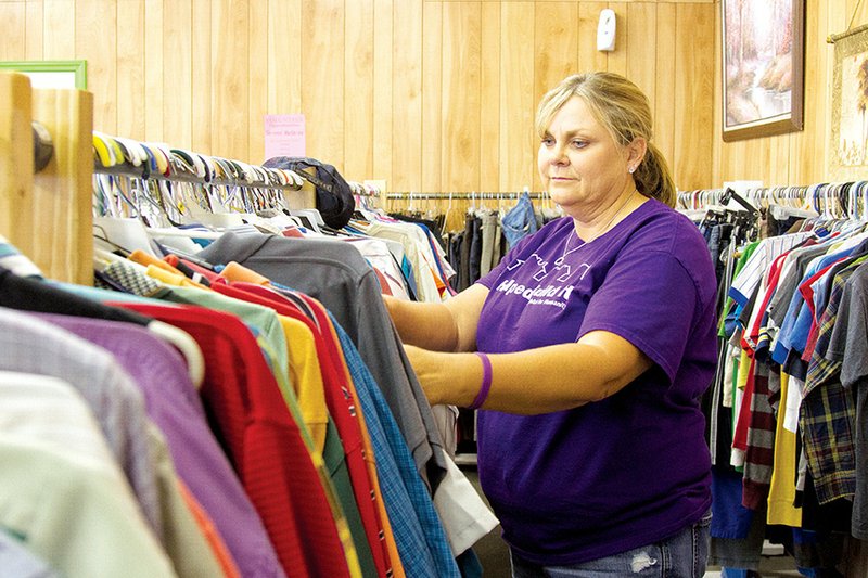 Leigh Anne Hawthorne, Habitat for Humanity of White County affiliate administrator, looks through some of the clothes offered for sale at the ReStore’s new location at 3702 E. Race Ave. in Searcy.
