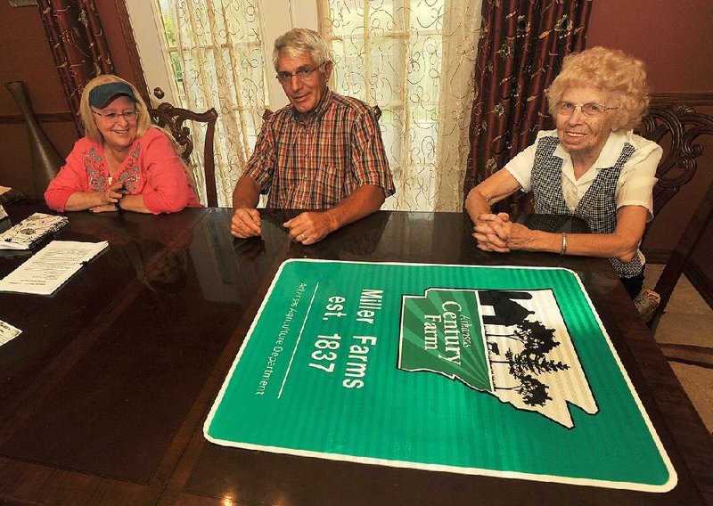 NWA Media/Michael Woods --08/27/2014-- w @NWAMICHAELW...(left to right) Cheryl Miller and her husband Sam Miller and Edythe Miler sit at the table with their new sign given to them by the Arkansas Agriculture Department to mark their farm as an Arkansas Century Farm.   The Miller family farm in the oldest farm in Arkansas.
