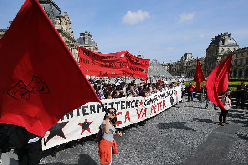 FILE - This June 16, 2014 file photo shows demonstrators holding a banner that reads: "Short Term Jobs, Unemployment, Precarious, It will Burst", during a march in front of the Louvre Museum, Paris, of part-time and temporary arts workers, striking artists and theater personnel, known as "intermittents", to protest against government plans to reform the unemployment benefits insurance agreement, Monday, June 16, 2014. The strike is gathering steam throughout the country, threatening the cancellation of various arts festivals like Avignon Theater festival this summer. Compare unemployment rates, and America’s job market looks much stronger than Europe’s. The U.S. rate for August, being released Friday, is expected to be a near-normal 6.1 percent. In the 18 countries that use the euro currency, by contrast, it’s a collective 11.5 percent. (AP Photo/Francois Mori, File)