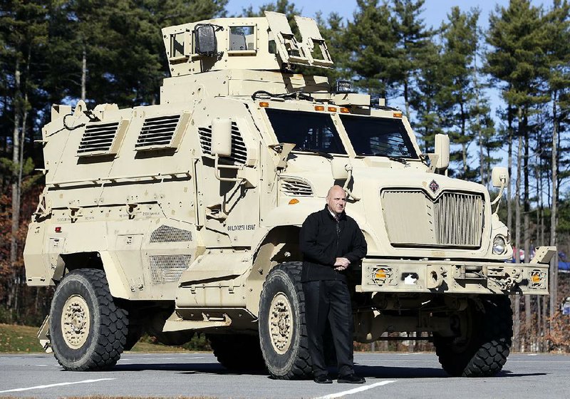 Cammack Village comptroller Woody Atha poses beside the town’s new surplus MRAP. The vehicle will help control scofflaws in the idyllic enclave that’s surrounded by Little Rock.