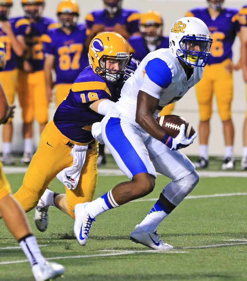 Arkansas Democrat-Gazette/RICK MCFARLAND--09/04/14--  North Little Rock's wr K.J. Hill looks for running room as Catholic's Harper Vondran (18) closes in (7) at War Memorial Stadium in Little Rock Thursday.