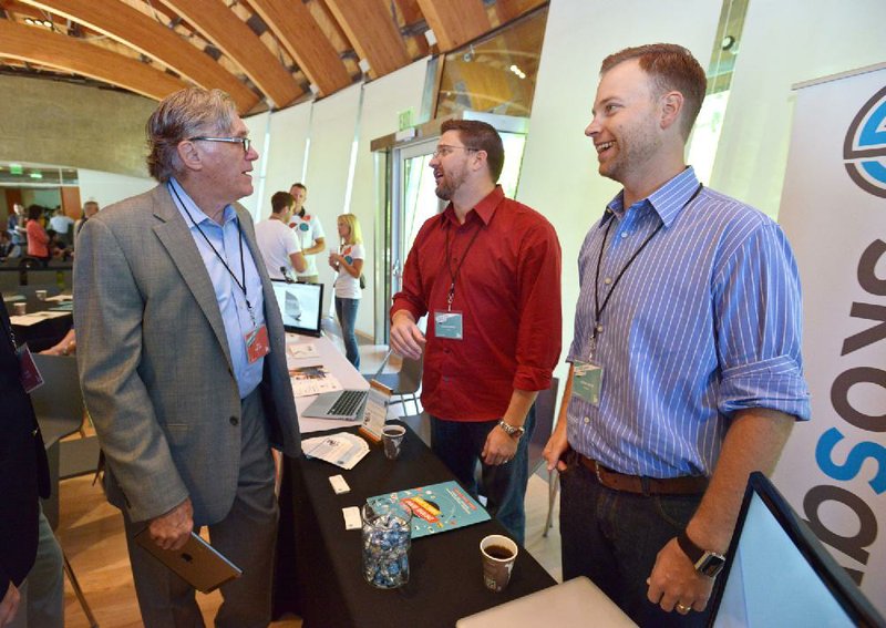 STAFF PHOTO BEN GOFF  @NWABenGoff -- 09/04/14  Tom Dalton, from left, director of Innovate Arkansas, visits with Jason Kohrig and Justin Urso, founders of Skosay, at their table during The ARK Challenge Demo Day in the Great Hall at Crystal Bridges Museum of American Art in Bentonville on Thursday September 4, 2014. The event was an opportunity for Skosay and four other local startups to pitch their brand and meet potential investors. 