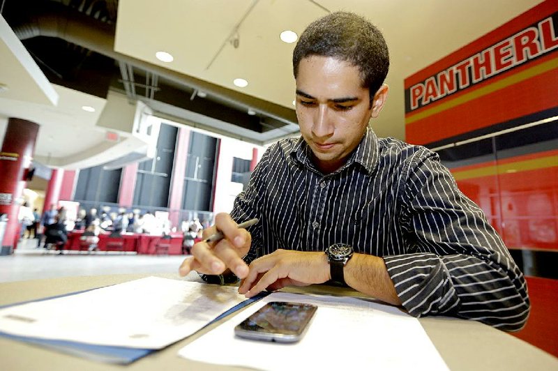 In this photo taken Tuesday, Aug. 19, 2014, Freddy Jerez, of Hollywood, Fla., fills out a job application during a job fair in Sunrise. Fla.  The government issues the August jobs report on Friday, Sept. 5, 2014. (AP Photo/Alan Diaz)