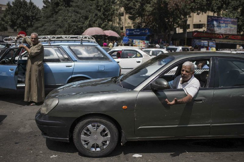 A man, right, talks to another driver as they wait in line for fuel at a gas station, one of the businesses affected by a power outage in Giza, Cairo's neighboring city, Egypt, Thursday, Sept. 4 2014. The man said he's been in line since six in the morning. He was there for three hours. Egypt suffered a massive power outage that halted parts of the Cairo subway, took TV stations off the air and ground much of the country to a halt for several hours Thursday, as officials offered no clear explanation for how the country suddenly lost 50 percent of its power generation. (AP Photo/Eman Helal)