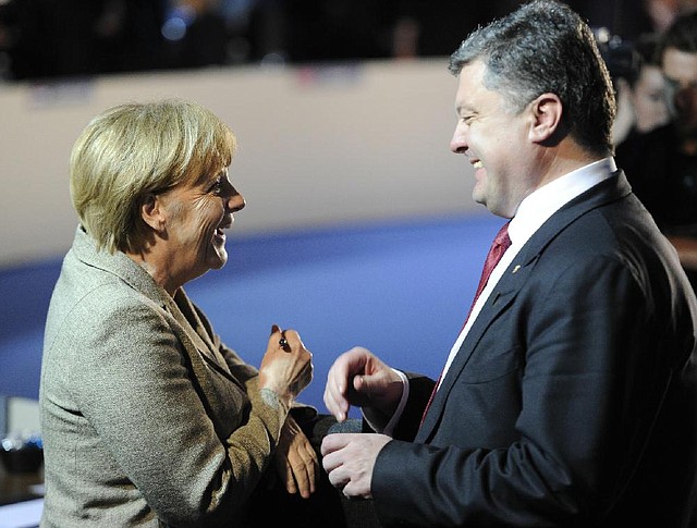 German Chancellor Angela Merkel talks with Ukrainian President Petro Poroshenko during NATO meetings Thursday in Newport, Wales. Poroshenko said he was ready for a cease-fire in eastern Ukraine if talks with separatists starting today in Minsk, Belarus, are successful.