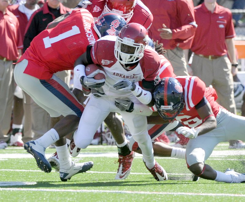 STAFF PHOTO MICHAEL WOODS &#8226; @NWAMICHAELW University of Arkansas receiver Marquel Wade is taken down by Ole Miss defenders in the 2011 matchup in Oxford, Miss. Passion for college football is especially strong in the South &#8212; in the Southeastern Conference and the Bible Belt. &#8220;I don&#8217;t think that&#8217;s a coincidence,&#8221; said the Rev. Leslie Belden, parish associate with First United Presbyterian Church in Fayetteville and a benefactor of the university.