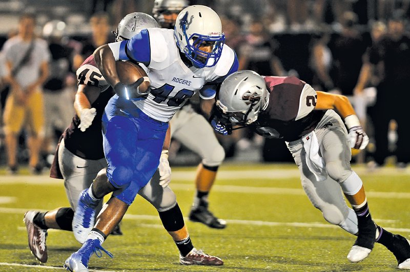  Staff Photo J.T. Wampler Bryan Grigsby, Rogers High senior, tries to get past Siloam Springs&#8217; Coby Roach, right, and David Goodman on Friday in Rogers.