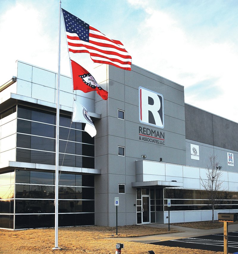FILE PHOTO BEN GOFF Flags fly in front of Redman &amp; Associates manufacturing and distribution facility in Rogers in December.
