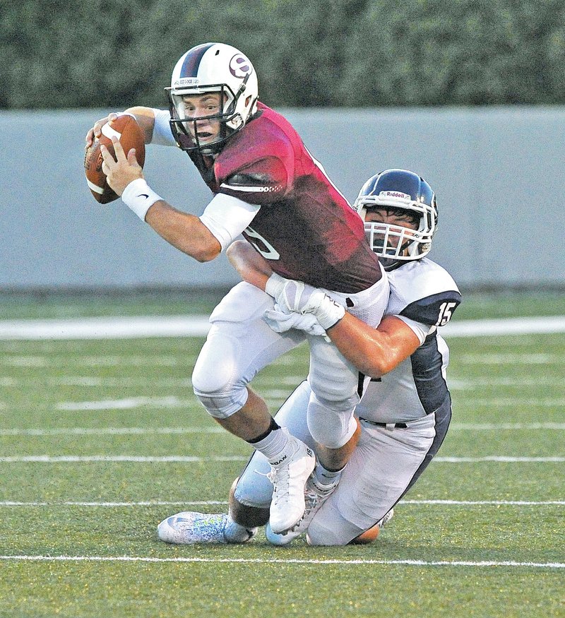  Staff Photo Michael Woods &#8226; @NWAMICHAELW Fuller Chandler, Springdale quarterback, is tackled by Greenwood defender Morgan Grant during the first half Friday in the Bulldogs season opener against Greenwood at Jarrell Williams Bulldog Stadium in Springdale.