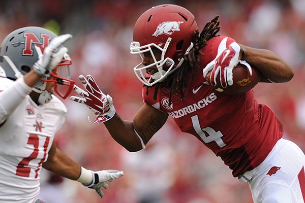 Arkansas receiver Keon Hatcher (4) reaches to fend off Nicholls defensive back Josh Singleton during the second quarter Saturday, Sept. 6, 2014, at Razorback Stadium in Fayetteville