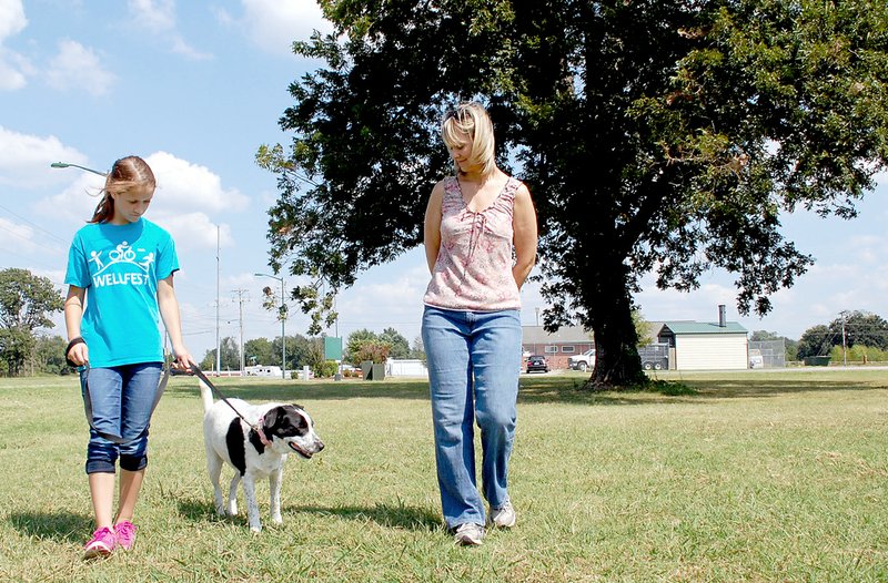 Tina Parker/Siloam Sunday Anne Jones and her daughter Eleri, 12, walk Blossom. Blossom was a wild dog, but has since been tamed with the help of Anne and Eleri.