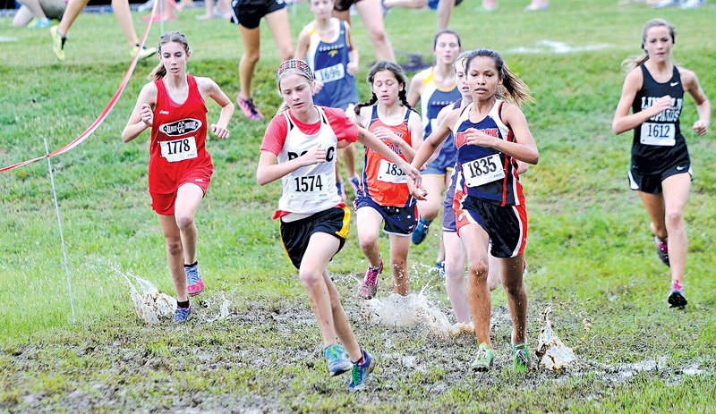 Staff Photo J.T. Wampler Competitors run through the mud Saturday at the Elkins Invitational Cross Country meet.
