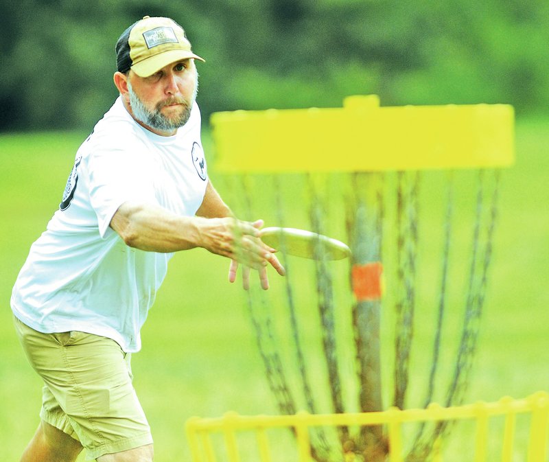 Staff Photo J.T. Wampler David Dodd of Fayetteville makes a birdie putt Saturday on hole 15 at Northshore Disc Golf Course during the ninth annual Northshore Invitational Disc Golf Tournament. The event was hosted by the Fayetteville Disc Golf Association and drew about 100 players from across the region.