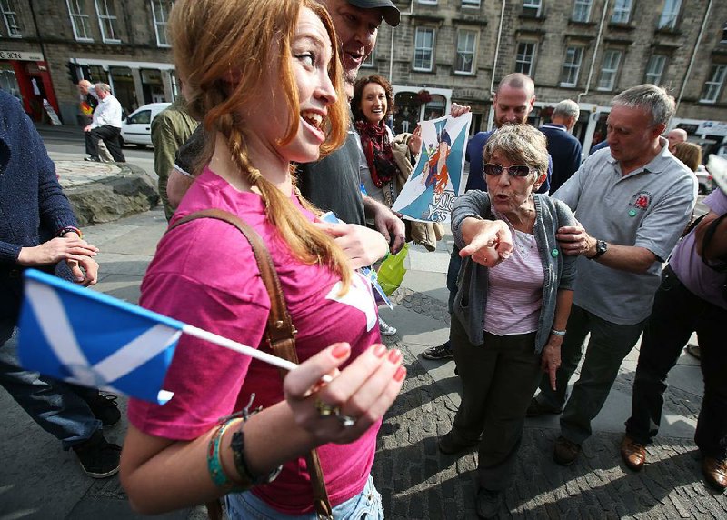 Vote Yes, and No, supporters exchange views with each other at the Grassmarket in Edinburgh during a tour by a politician ahead of the Scottish Independence referendum, Monday Sept. 8, 2014. The Member of Parliament is visiting  100 streets in 100 days  making his case for a No vote in the referendum which takes place on September 18. (AP Photo/PA,  Andrew Milligan)  UNITED KINGDOM OUT  NO SALES  NO ARCHIVE