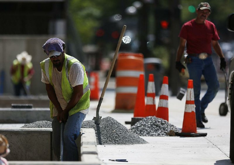 Arkansas Democrat-Gazette/MELISSA SUE GERRITS - 09/08/2014 - Darin Mix with Township Construction levels stone in an area on Main street between 3rd and 4th street September 8, 2014. Beginning September 10, Main Street between Fourth and Third will be closed to thru traffic as work continues on the Main Street Creative Corridor project. The project includes various permeable sections of sidewalk which will allow some cleansing of rain water and flow of that rain water back to the river. 