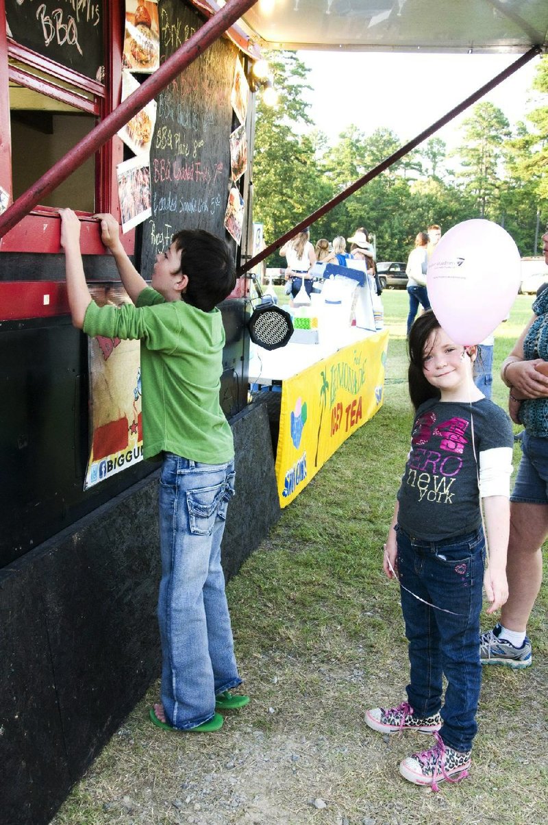 Lucas and Emily Hawthorn wait for their barbecue from Big Guns BBQ, one of the food vendors at the Montgomery County Fair. 
