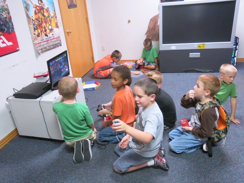 Photo by Susan Holland Several students at Imagine Before and After School Care enjoy board games and video games in the popular game room. A homework session is always the first activity when youngsters arrive in the afternoon. Then they are free to go to the game room and choose an educational game.