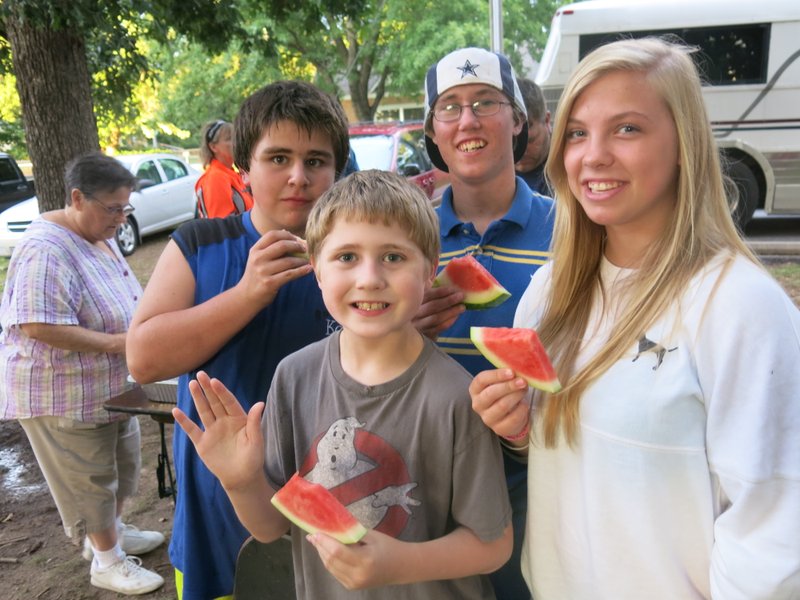 Photo by Susan Holland This group of youngsters was among the crowd enjoying the free watermelon at Gravette&#8217;s &#8220;Spittin&#8217; and Pickin&#8217; in the Park&#8221; at Kindley Park Saturday night. Mayor Byron Warren welcomed the crowd and Margo Thomas, left, city council member, helped serve melon wedges at the event which also featured gospel singing.