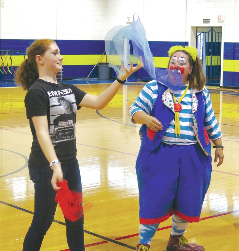 Photo by Mike Eckels Browlyn Berry, with assistance from Skeeter the clown, attempts to juggle scarves during a Decatur Middle School assembly at Peterson Gym Sept. 5.