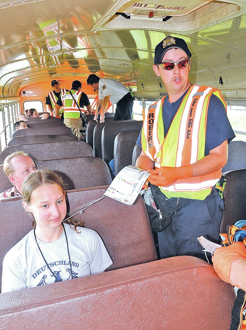 STAFF PHOTO FLIP PUTTHOFF Nick Mason, Rogers firefighter, treats mock-victim Sarah Ashley on Tuesday during an airplane-crash drill at the Rogers airport. Ashley is a student at NorthWest Arkansas Community College and one of several students who played crash-victim roles.
