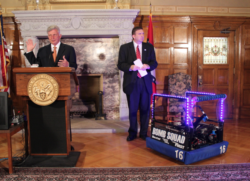 Gov. Mike Beebe speaks beside a Mountain Home High School robot while announcing a high school robotics competition set to come to Little Rock next year.