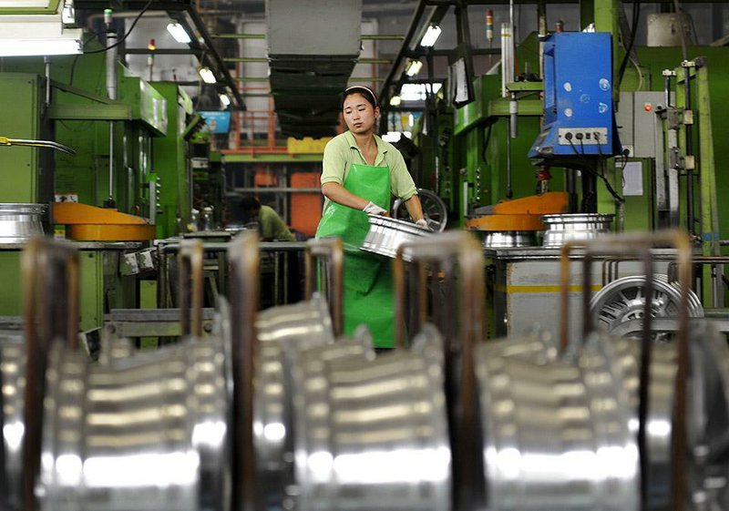 A woman works last month at an aluminum wheel factory in Zouping, China. Chinese Premier Li Keqiang promised Wednesday to open China wider to foreign companies.