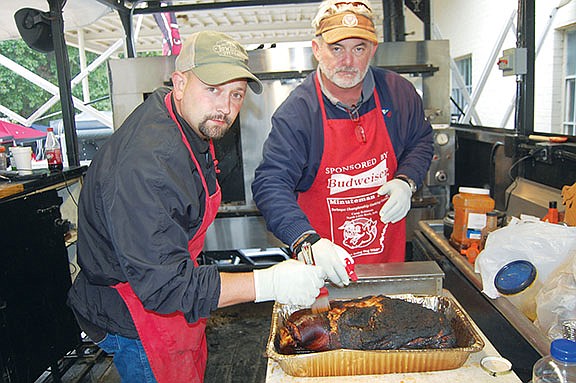 Brandon Magness, left, and Jim Butler of the Partyq barbecue team from Batesville prepare a pork shoulder for the Go Hog Wild State Championship BBQ Competition during the 2012 Timberfest. This year, the barbecue competition, scheduled for Oct. 4 in Sheridan, will be sanctioned by the Kansas City Barbecue Society, and Timberfest officials are looking for more teams for the contest.