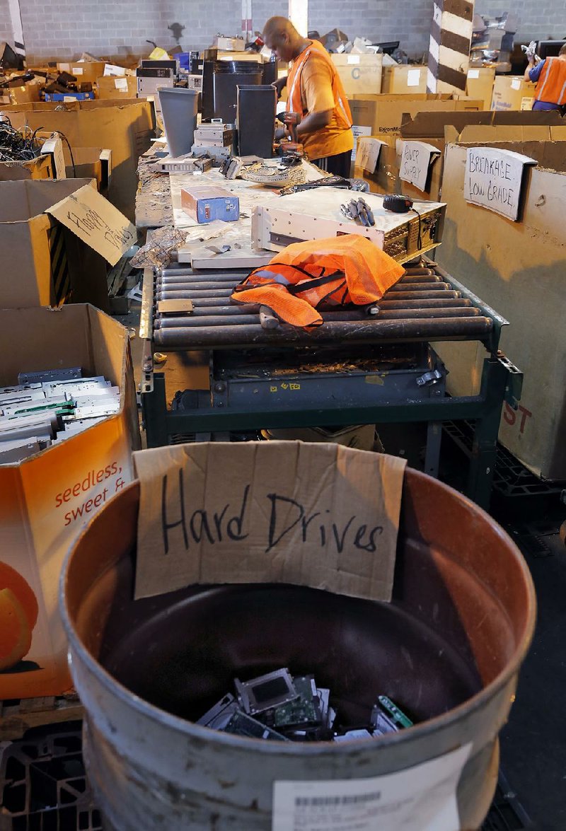 Recyclers (including Trevor Thomas above) separate and disassemble electronic items at eSCO Processing and Recycling’s warehouse on East 23rd Street in Little Rock.