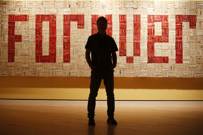 John Salvest, an artist and professor of art at Arkansas State University, stands in front of Forever, which was assembled from romance novels. The work is part of a new exhibition at Crystal Bridges Museum of American Art titled “State of the Art: Discovering American Art Now.” It hangs through Jan. 19.