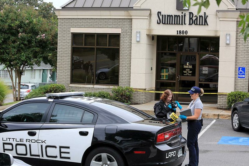 Arkansas Democrat-Gazette/RICK MCFARLAND --09/11/14--  Little Rock Police Department crime scene technicians clean a camera lens during the gathering of evidence at the scene of a bank robbery at the Summit Bank, 1800 N. Taylor St. in Little Rock Thursday.