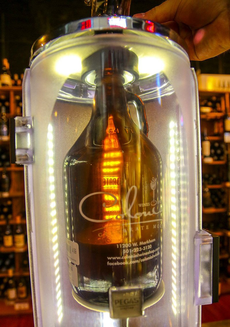 9/11/14
Arkansas Democrat-Gazette/STEPHEN B. THORNTON
Colonial Wines & Spirits' beer growler at work, removing air and flowing beer down the sides to prevent foaming. 