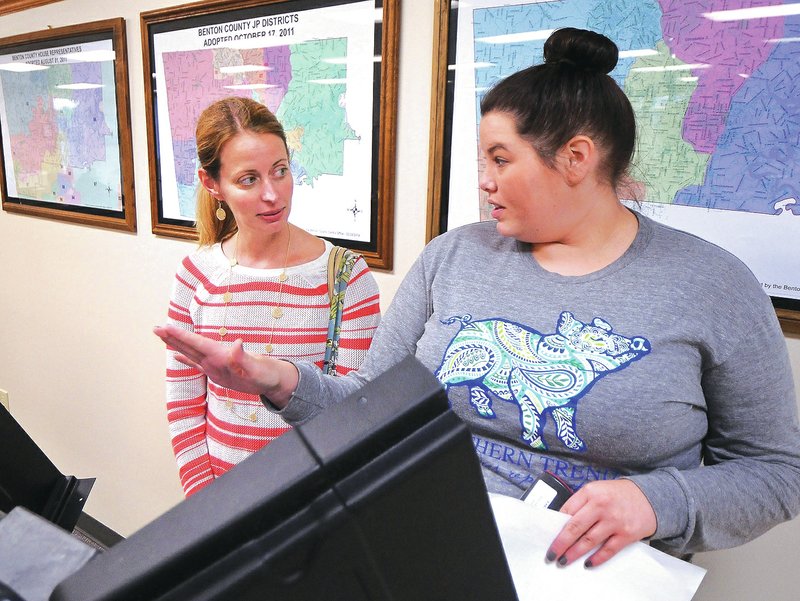 STAFF PHOTO BEN GOFF &#8226; @NWABenGoff Kari Horton, right, deputy clerk of voter registration, gives Katie Gottlieb instructions Friday as she casts her ballot during early voting for school board at the Benton County Clerk&#8217;s office in the county administration building in Bentonville.