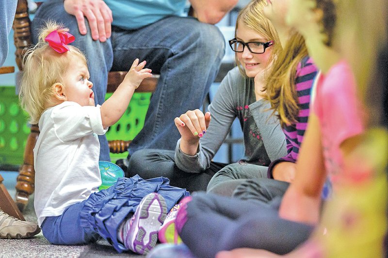 STAFF PHOTO JASON IVESTER Callie Anne Cook, 21 months, waves Friday to Westside Elementary School fifth-grader Hannah Stone in Lee Ellen Jones&#8217; class at the Rogers school. Callie Anne&#8217;s mother, Jamie Cook, talked to the class about Apert syndrome.