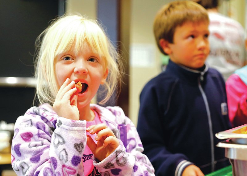 STAFF PHOTO DAVID GOTTSCHALK Lily Duncan, a second-grader at Happy Hollow, tastes a bell pepper.