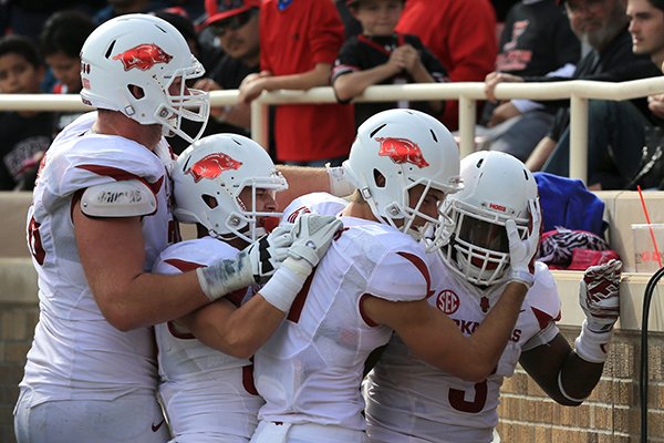 Arkansas running back Alex Collins (far right) celebrates after an 84-yard touchdown run with teammates Dan Skipper (from left), Brandon Allen and Cody Hollister during the fourth quarter of a game at Jones AT&T Stadium in Lubbock, Texas on Saturday on Sept. 13, 2014.