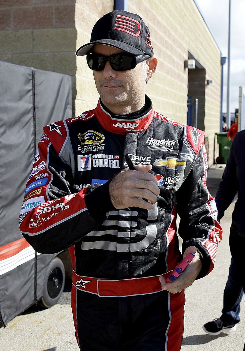 Driver Jeff Gordon walks to his garage during a practice for the NASCAR Sprint Cup Series auto race at Chicagoland Speedway in Joliet, Ill., Saturday, Sept. 13, 2014. (AP Photo/Nam Y. Huh)